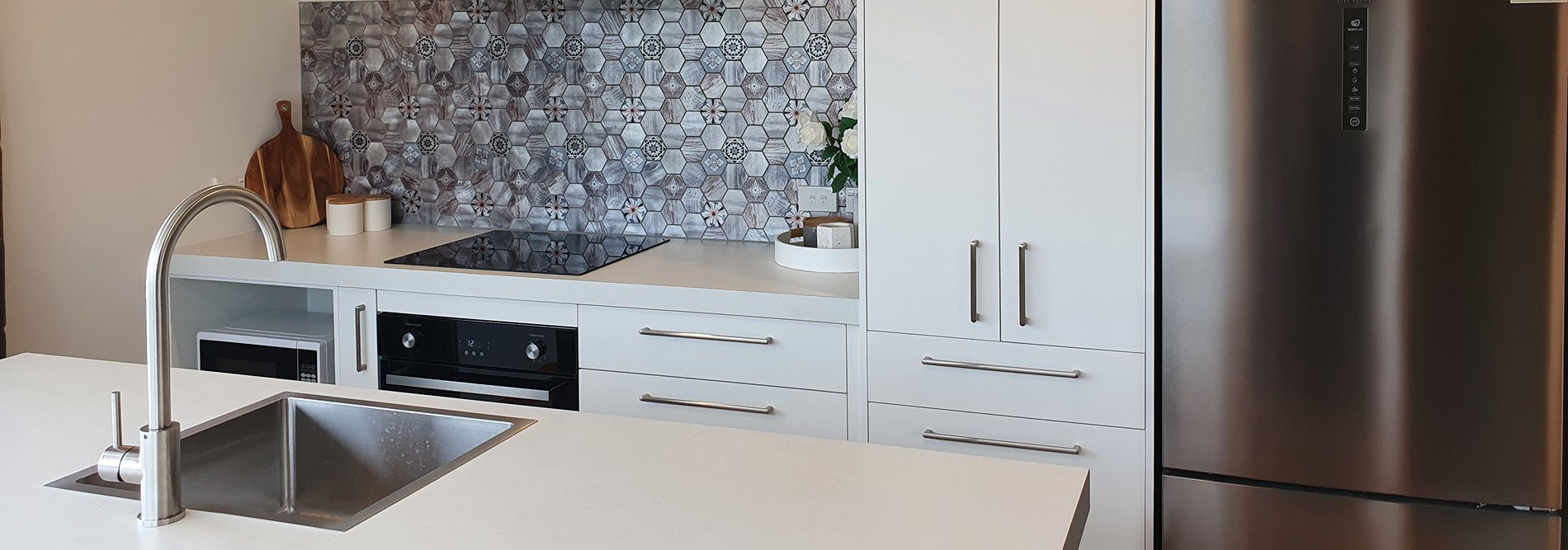 white kitchen with island and vibrant splashback