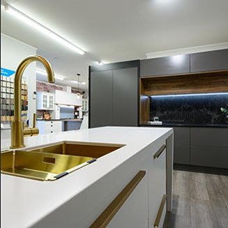 Kitchen showroom with white counter top and brass accessories